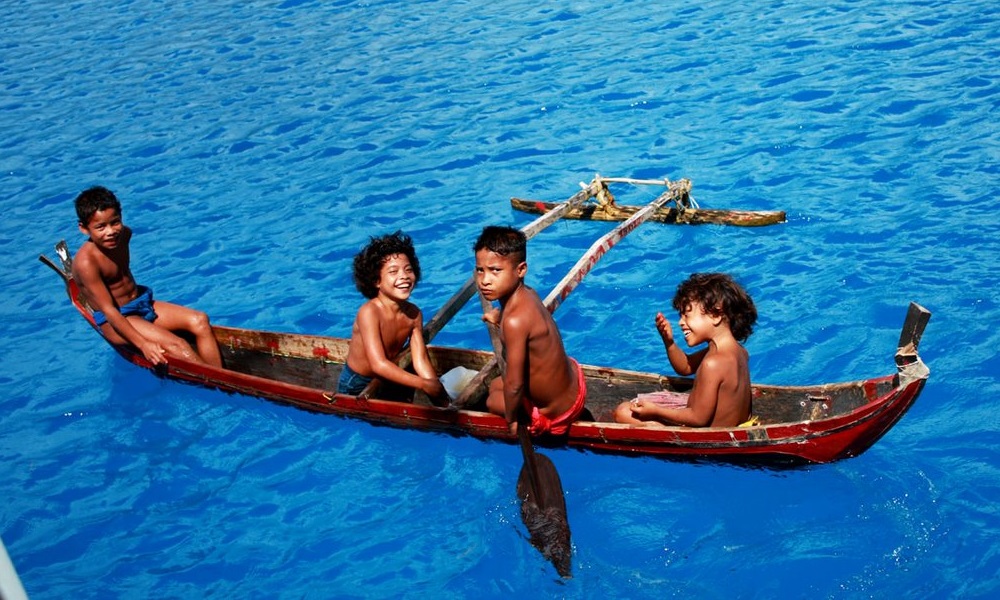 イファリク環礁のラグーンでカヌーに乗って遊ぶ子供たち